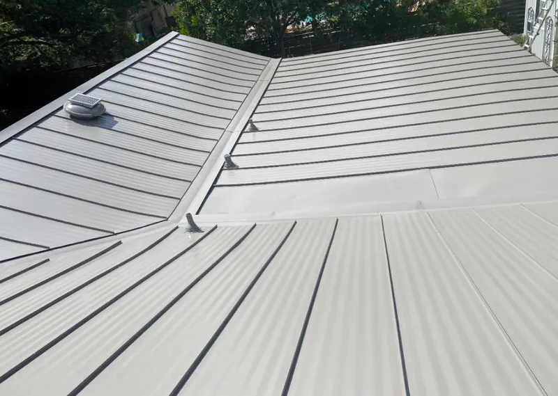 Solar attic fan installed on a metal roof for Roof Ventilation in Hasbrouck Heights