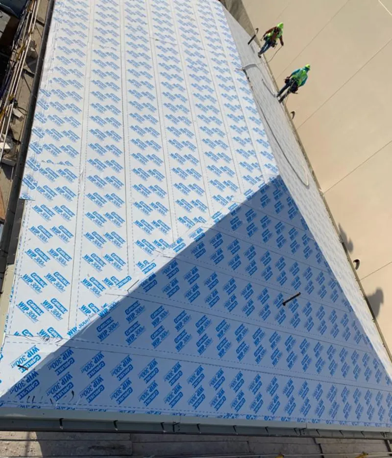 Professional roofers installing underlayment on a metal roof in Hasbrouck Heights